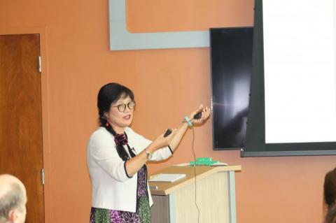 Mei-Hung presenting, using her hands to motion to a spot on the PowerPoint.